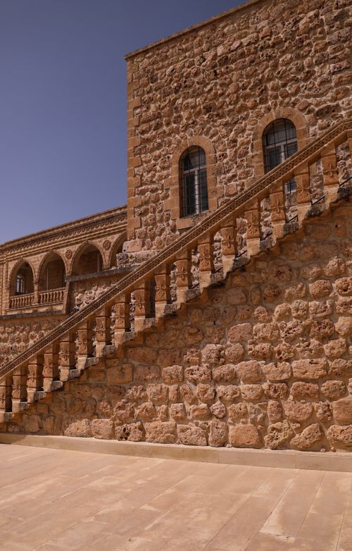 Free Exterior view of a historic stone building with detailed architecture and staircase. Stock Photo