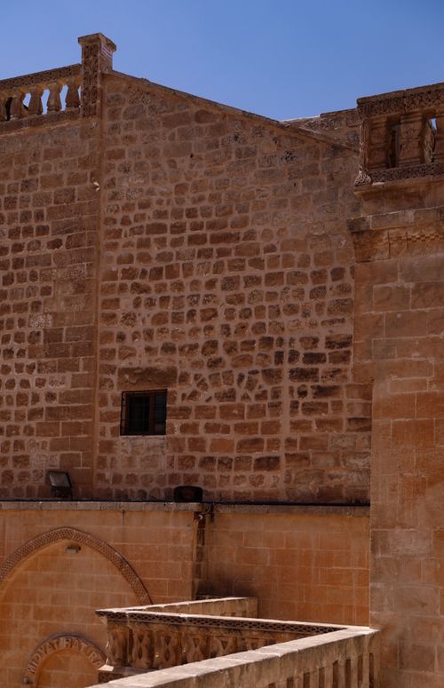 Free Close-up of a historic stone building exterior under a clear blue sky. Stock Photo