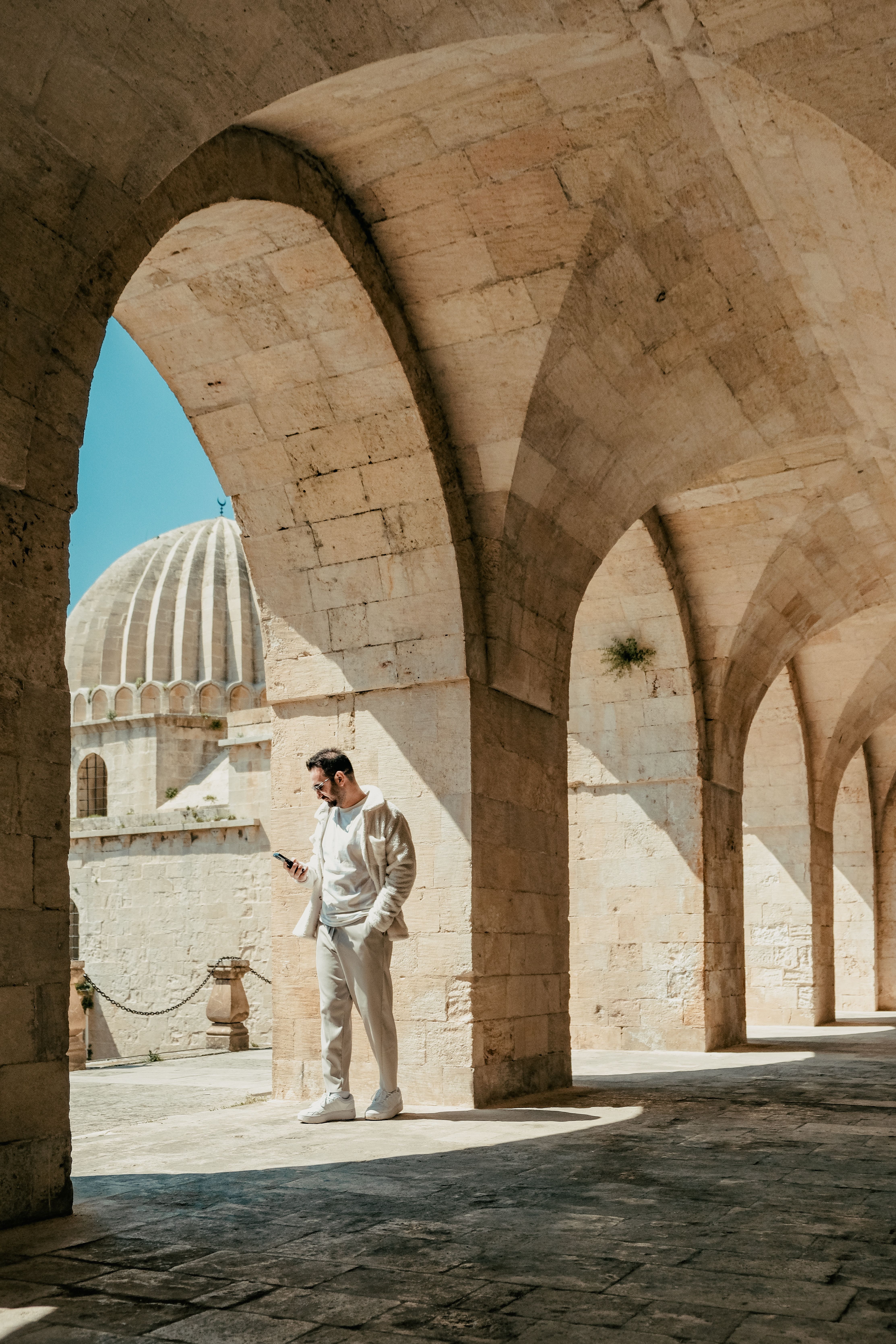 Man Exploring Ancient Stone Architecture Corridor · Free Stock Photo