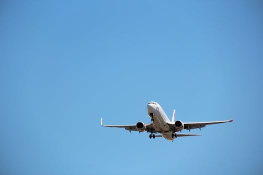 Virgin Australia aircraft captured mid-landing against a clear blue sky at Melbourne Airport.