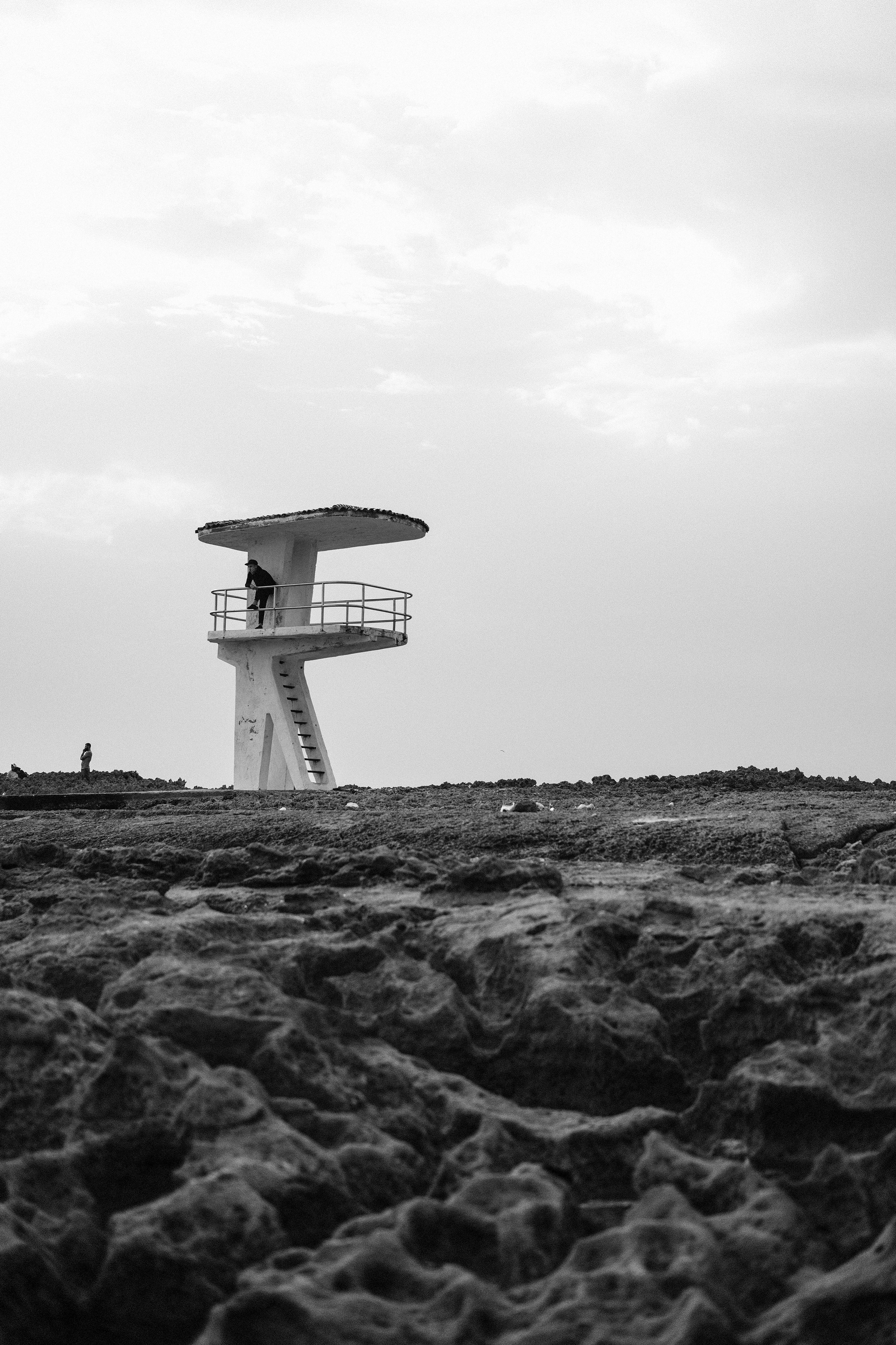 Monochrome image of a lifeguard tower on a rocky beach in Rabat, Morocco.