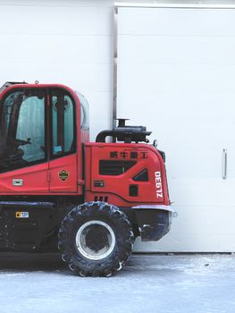 Side view of a red industrial vehicle against a white background.
