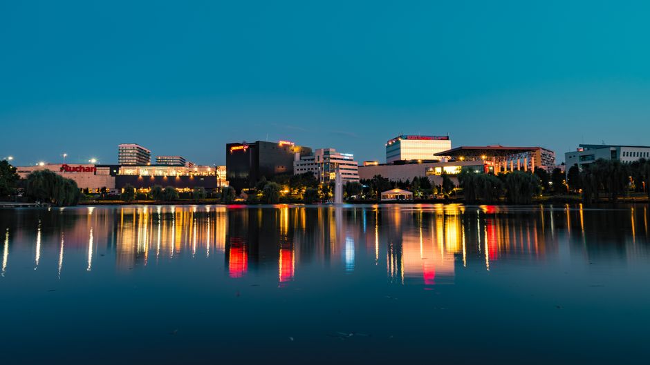 Stunning urban nightscape with colorful reflections over a serene waterfront. Ideal for modern architecture themes.
