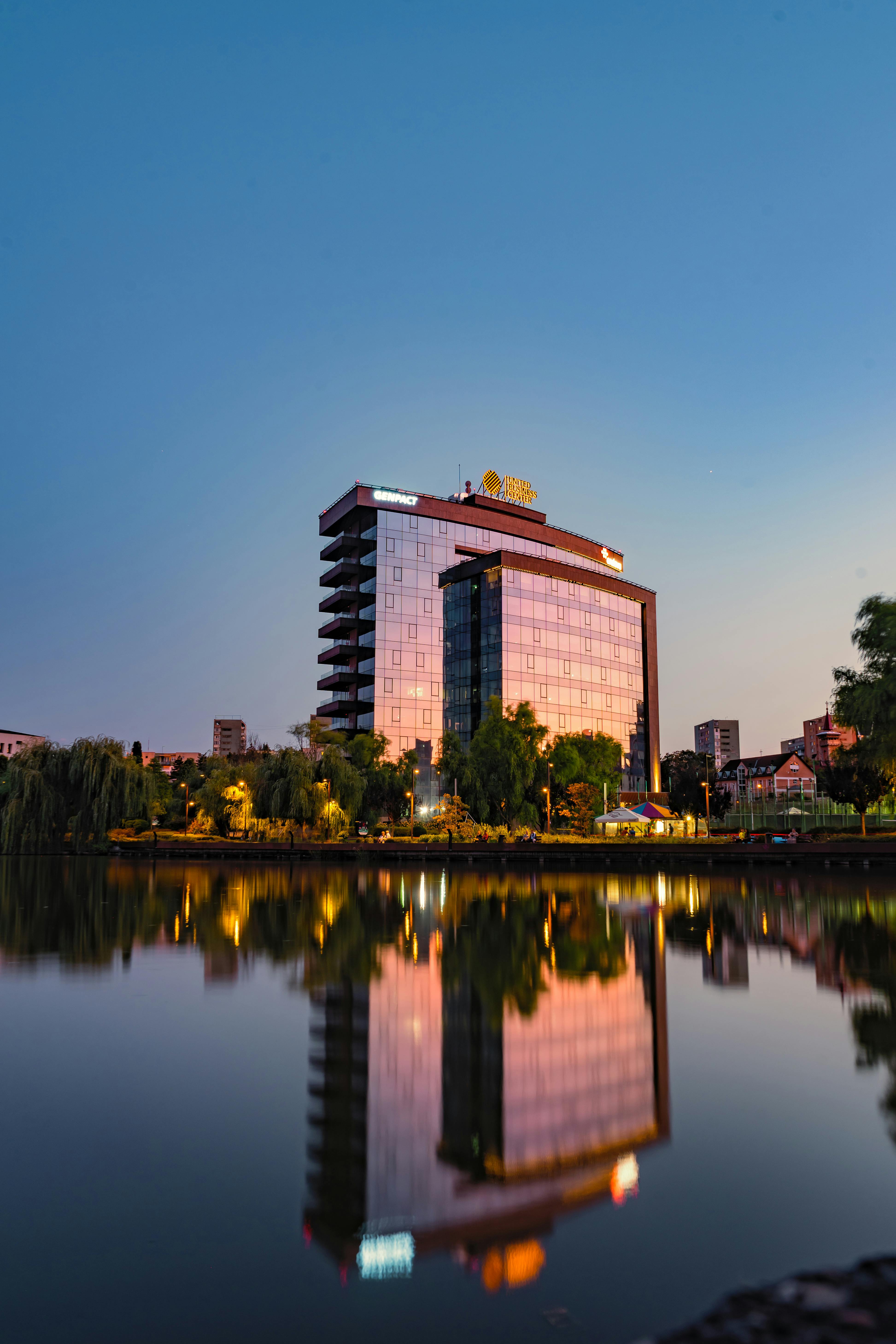 这是一家令人惊叹的现代酒店，黄昏时分映衬着宁静的湖泊和城市天际线