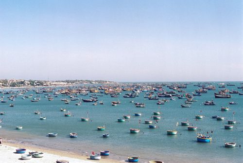 Free Colorful fishing boats fill the serene waters of Phan Thiết, creating a beautiful seascape. Stock Photo