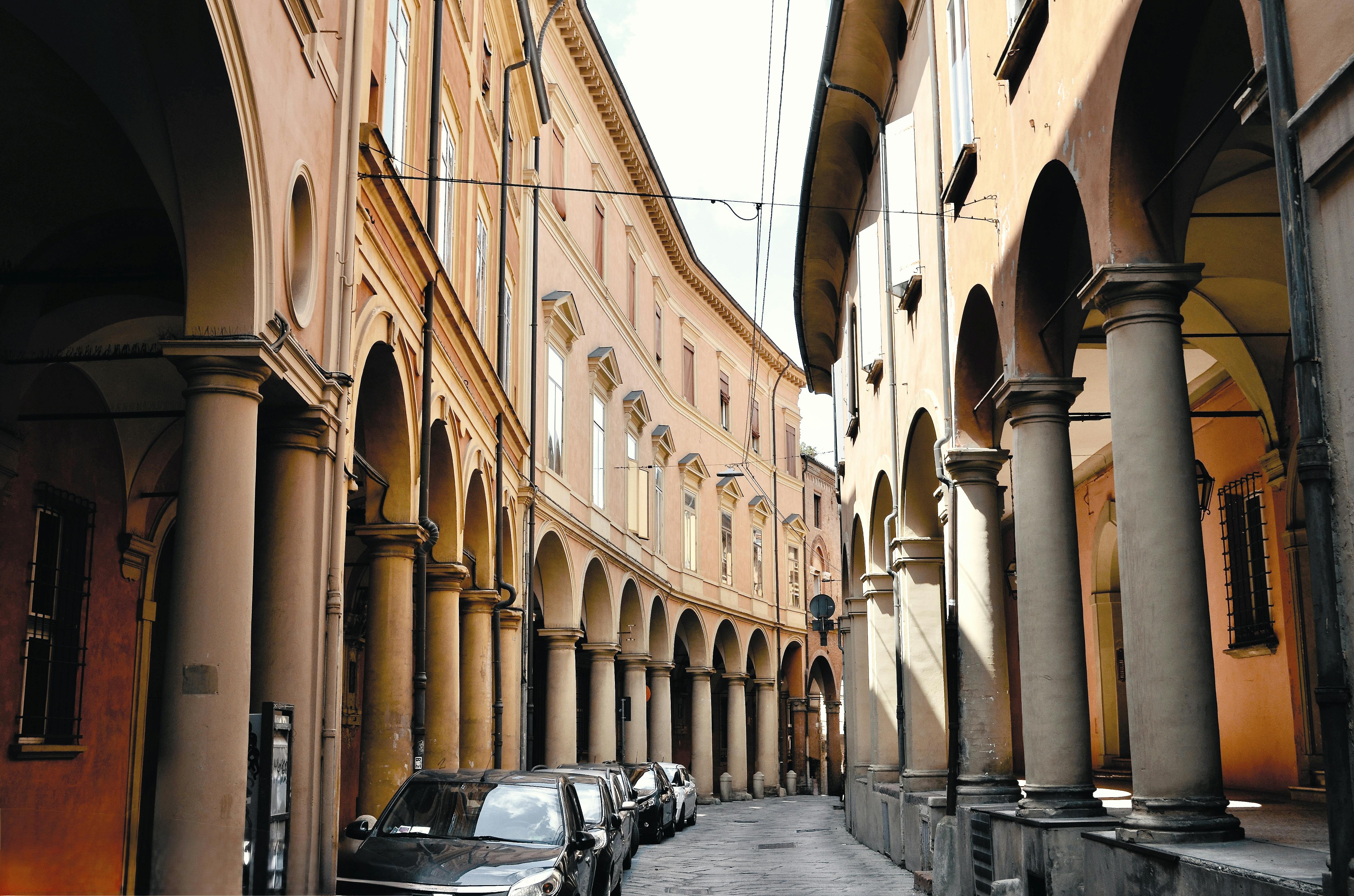 Explore the historic arcades of Bologna, Italy, lined with elegant columns.