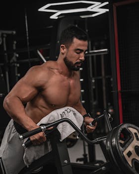 Strong man working out in a gym lifting weights on a machine. Fitness and strength training concept.