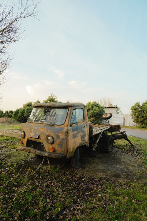 Free A vintage abandoned truck sits surrounded by fall foliage in a rural Kaliningrad setting. Stock Photo
