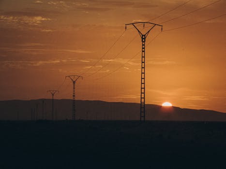 Serene Algerian landscape with power lines stretching into the distance at sunset.