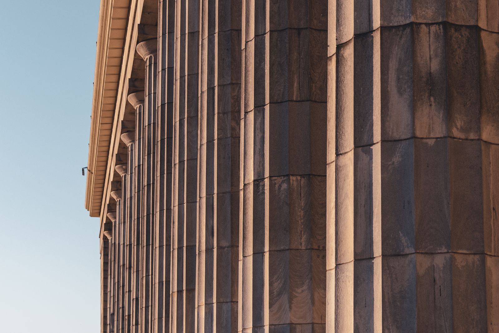 Warm sunlight across classical stone columns — the plinth a structure stands on.