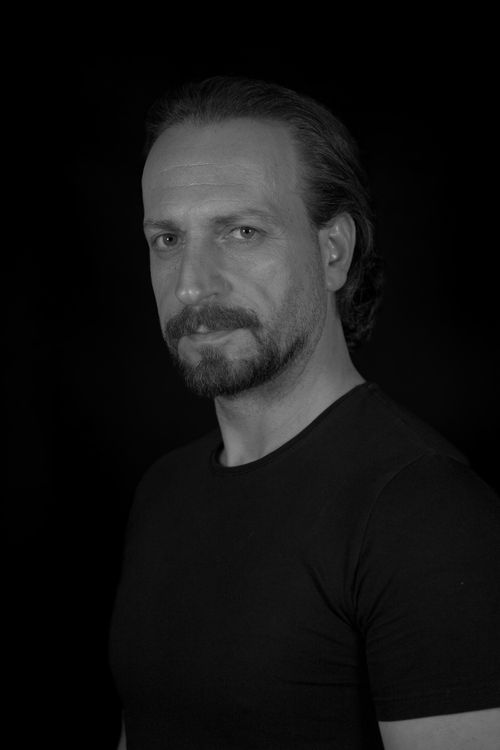 Free Moody black and white portrait of a bearded man in a dark shirt. Stock Photo