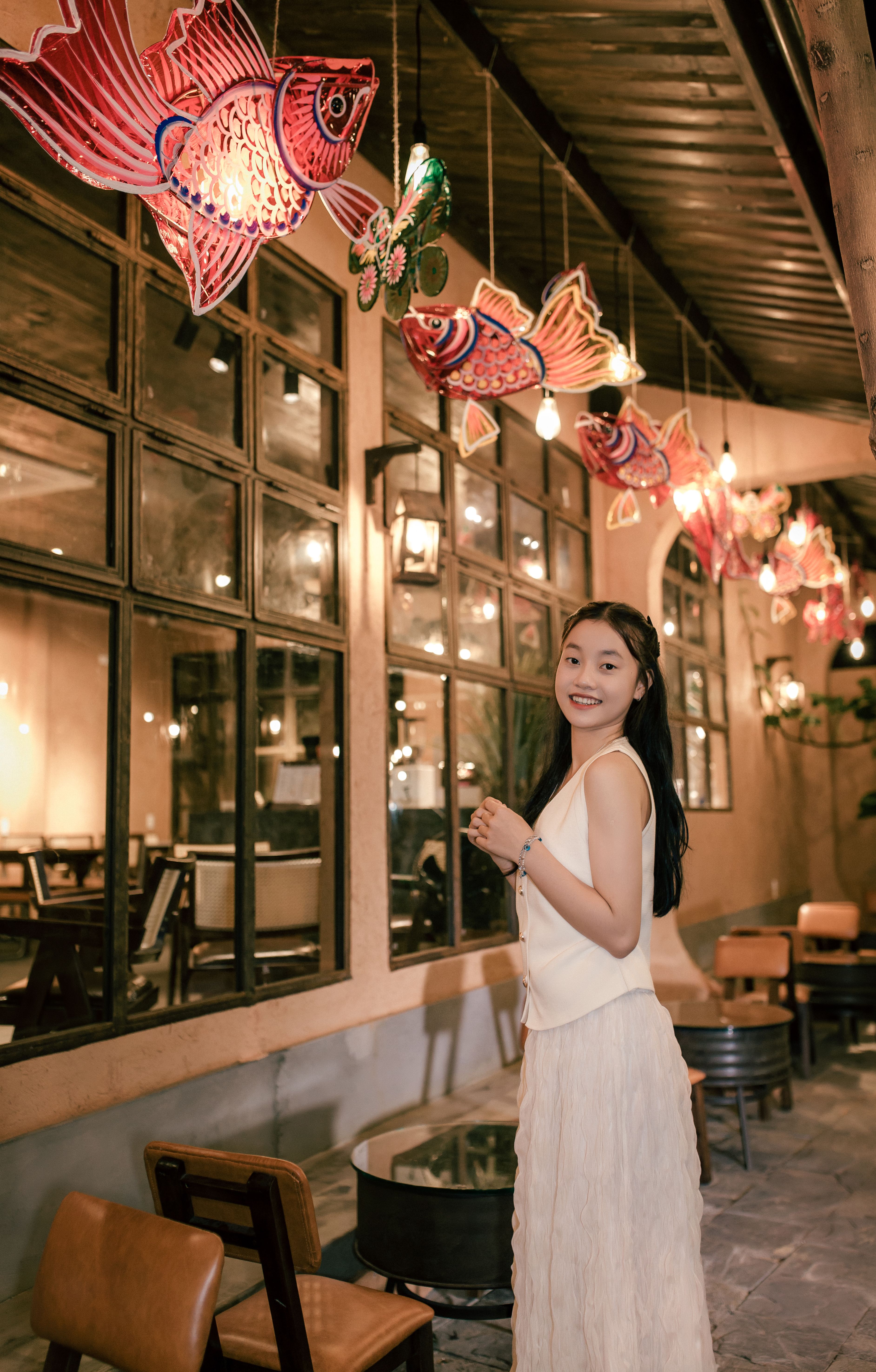 Young woman in Hội An with vibrant lanterns at night.