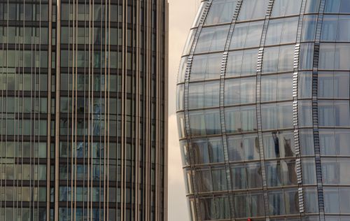 Free Close-up of two modern skyscrapers with unique glass facades in an urban setting. Stock Photo