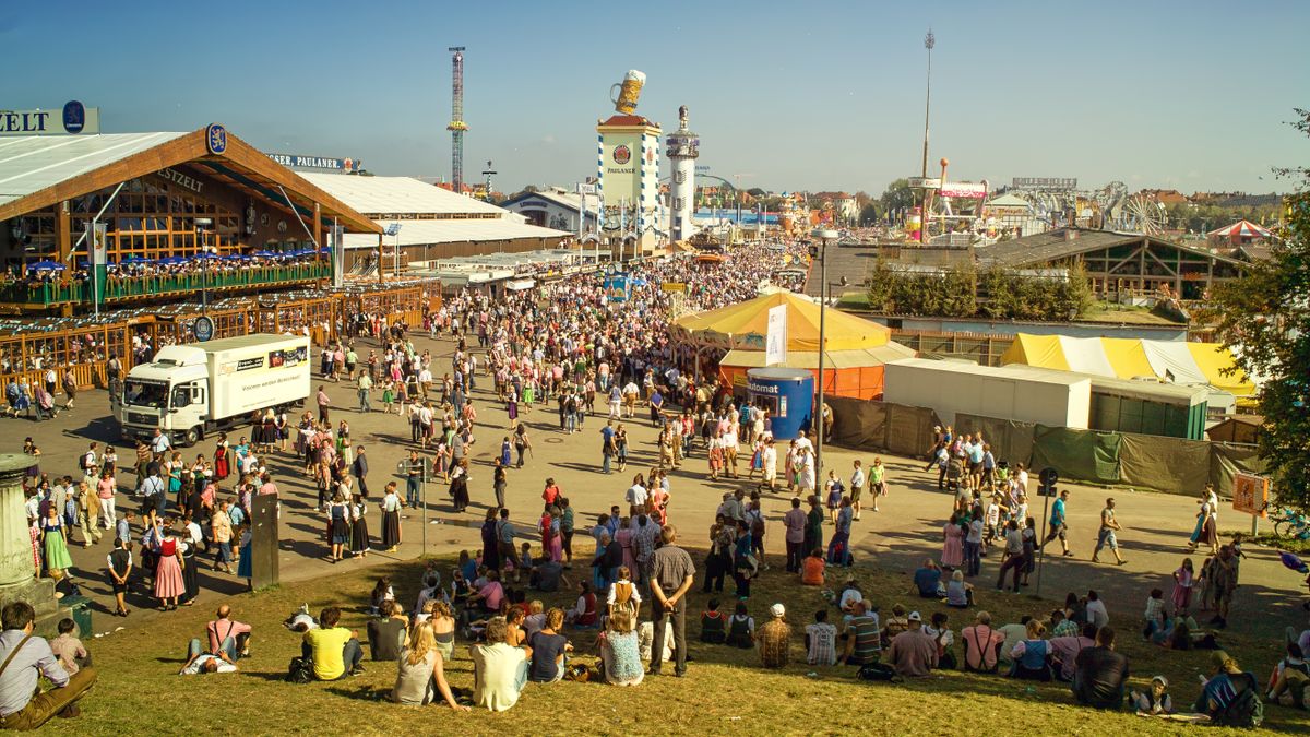옥토버페스트 — A bustling scene of people gathered at Oktoberfest, Munich, showcasing traditional attire and lively atmosphere.