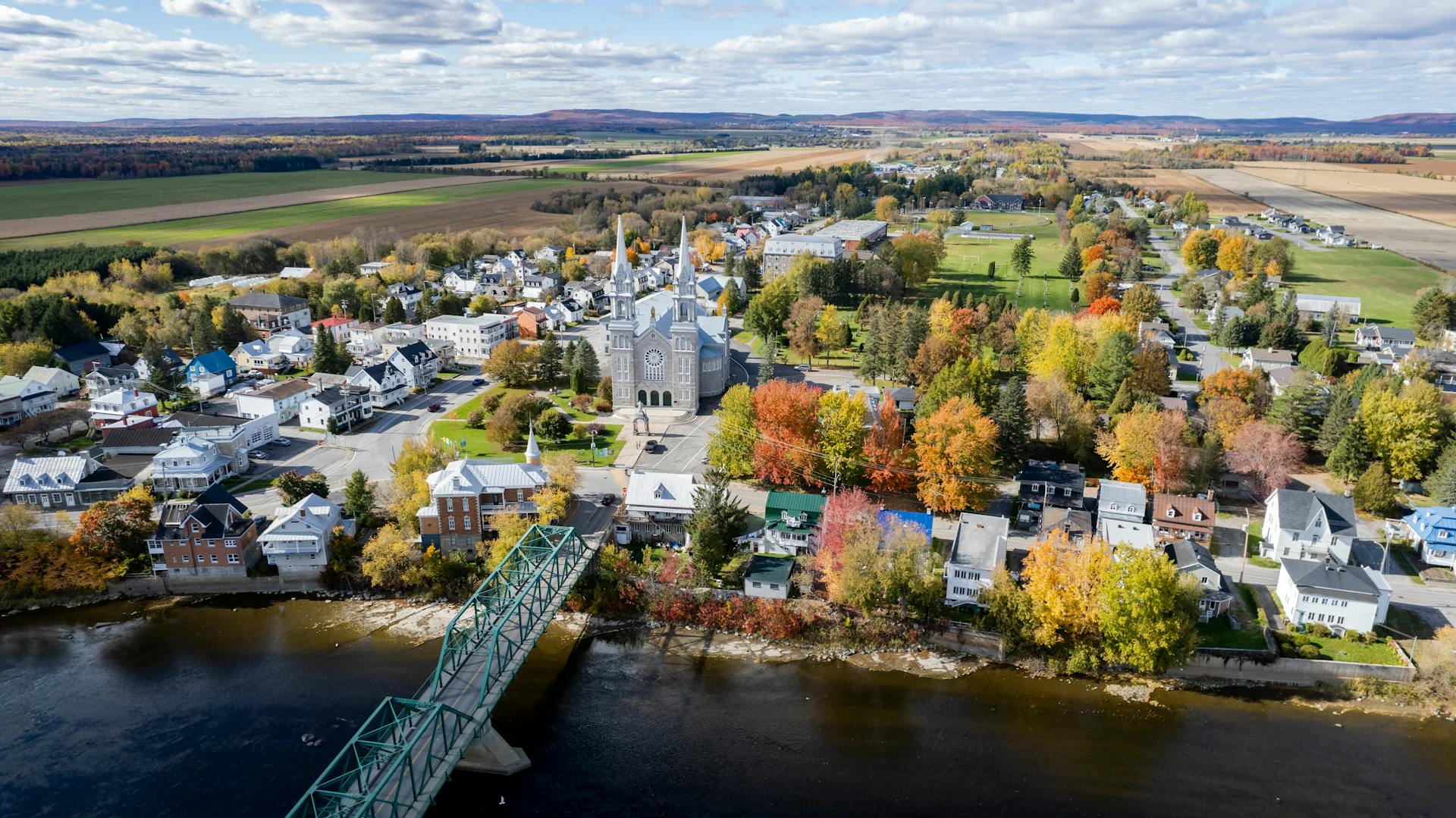 Aerial drone view of a village in Quebec, Canada during a sunny autumn day. Landscape horizon.