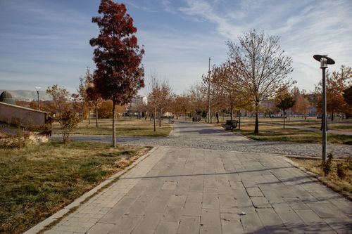 Free A serene park pathway lined with autumn trees in Elazığ, Türkiye, under a clear blue sky. Stock Photo