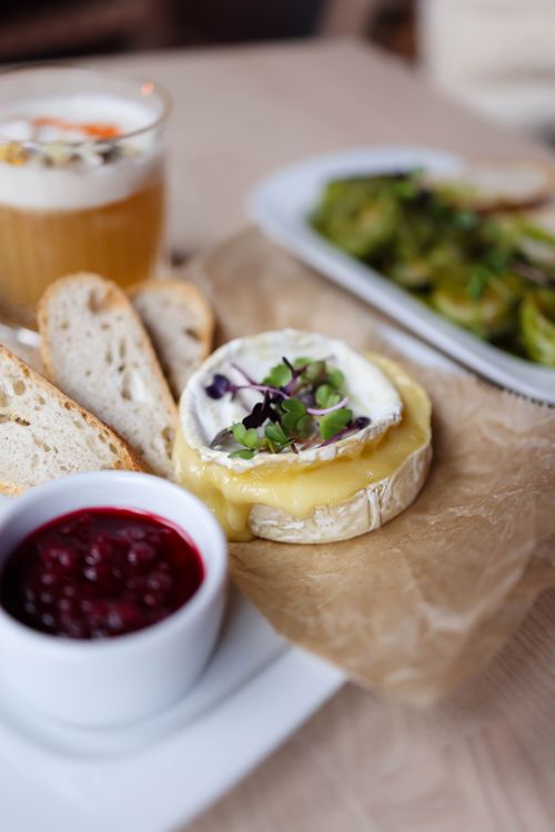Free Delicious baked brie with fresh baguette slices and berry jam, perfect for a gourmet meal. Stock Photo