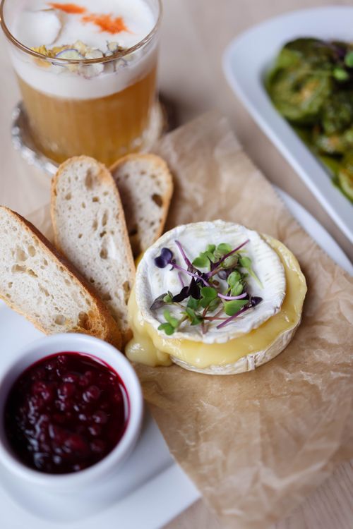 Free Delicious brie cheese with bread, raspberry jam, and a refreshing cocktail. Stock Photo