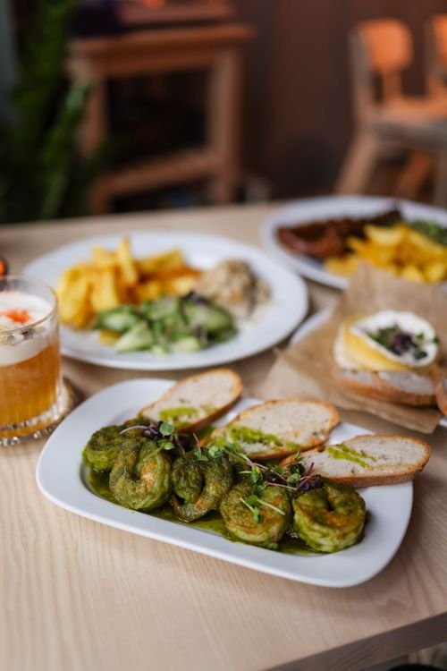 Free A variety of vegetarian dishes presented elegantly on a wooden table, including bread and vegetable fritters. Stock Photo