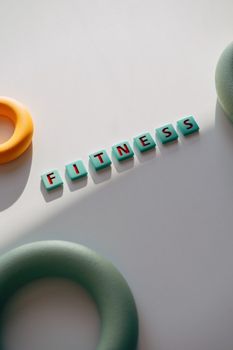 Colorful rings and letters spelling 'Fitness' create a vibrant workout theme.