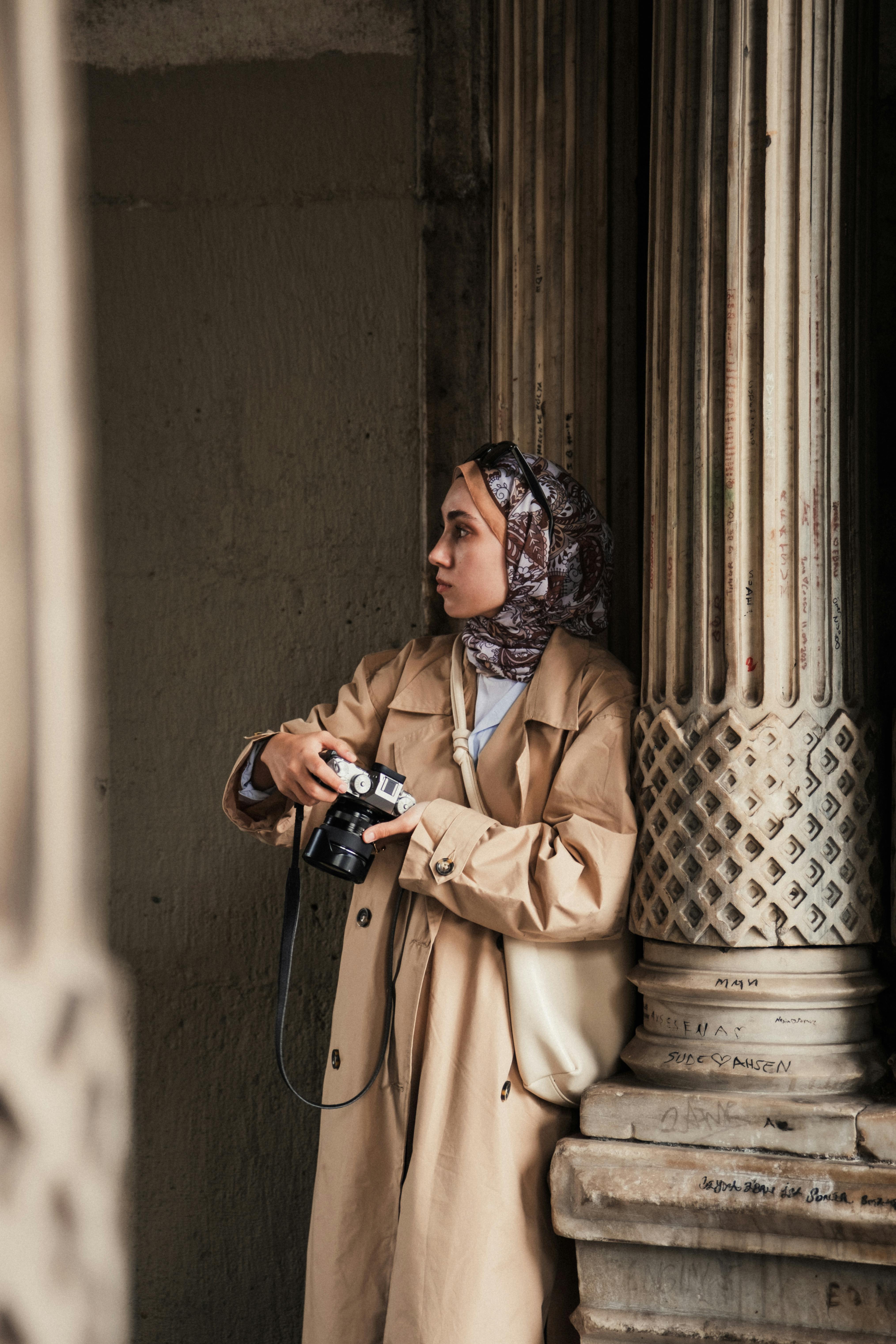 A young woman with a camera in a historic Istanbul archway, capturing moments.