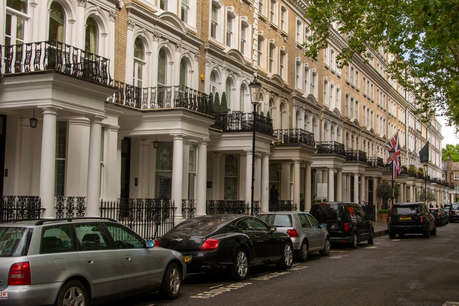 Row of luxury Georgian terrace houses with parked cars in London, United Kingdom.