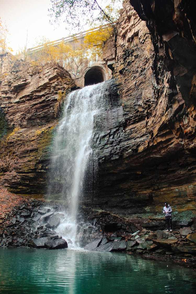 A Person Under The Flowing Waterfall