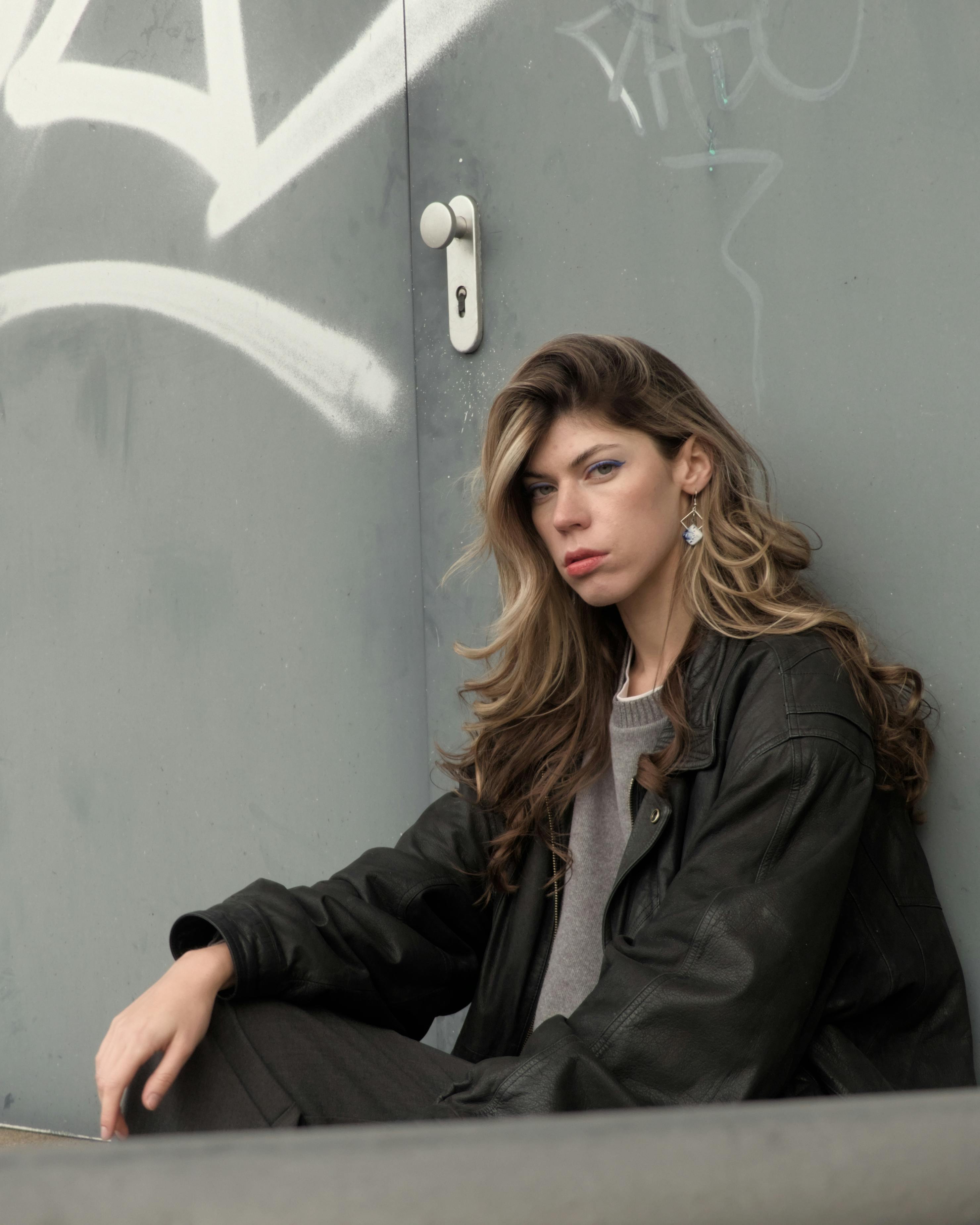 stylish woman posing against urban graffiti wall