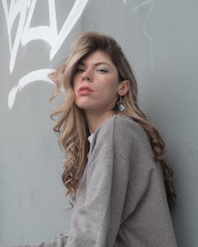 A fashionable woman poses confidently by a graffiti wall in Berlin.