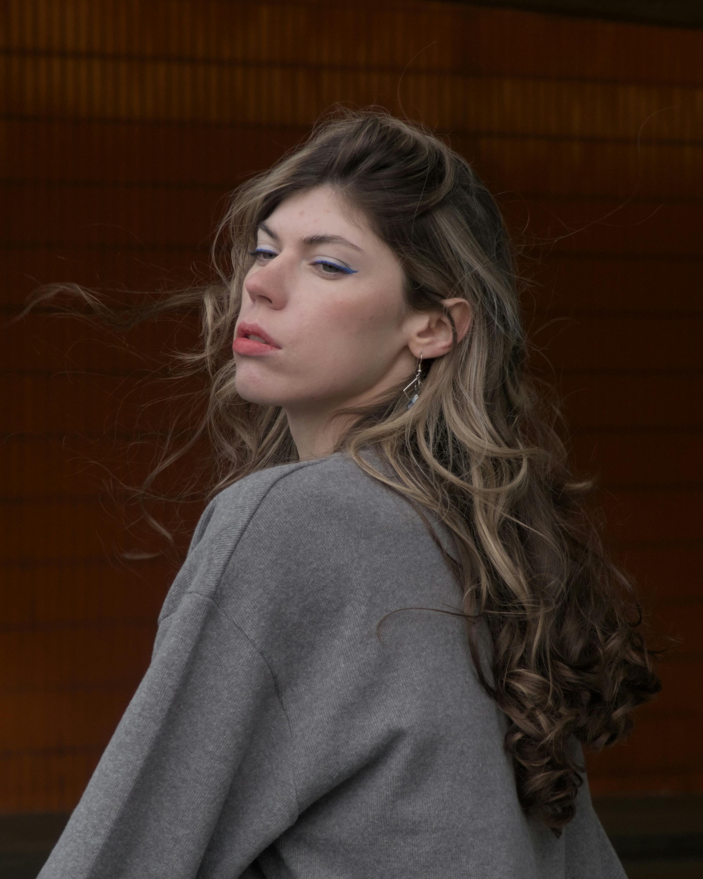 portrait of a person with windswept hair in berlin