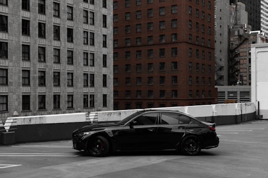 A stylish black car parked on a rooftop amid Chicago's urban backdrop.
