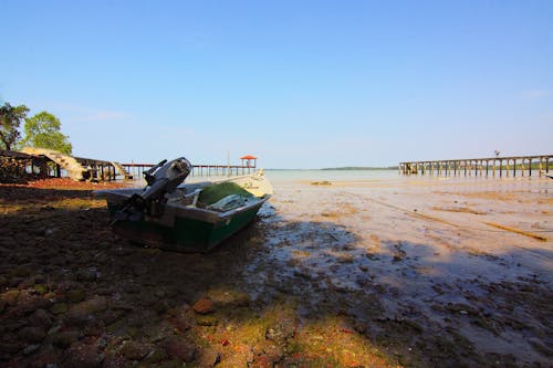 Boat With Outboard Motor on Seashore during Low Tide