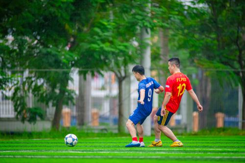 Free Two adults playing soccer on a lush green field in Hanoi, Vietnam. Stock Photo