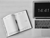 Flat Lay Photography of Unfold Book Beside Macbook