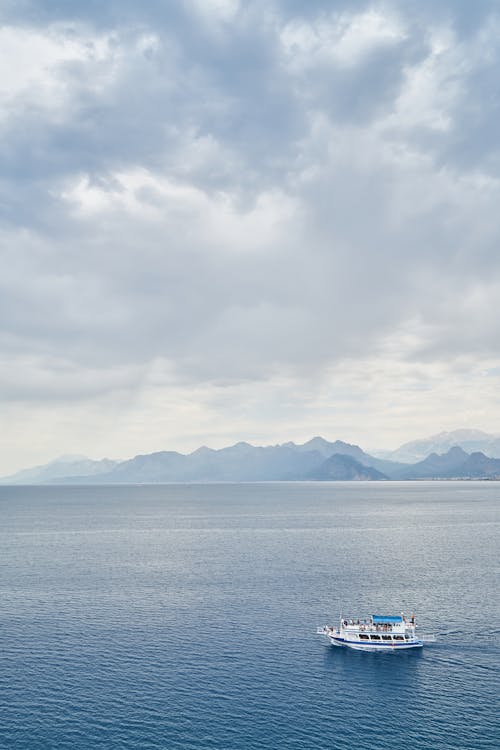 White Boat on Ocean Water during Cloudy Day