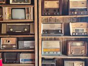 A nostalgic display of vintage radios and retro TV on wooden shelves, capturing timeless charm in Dubai.