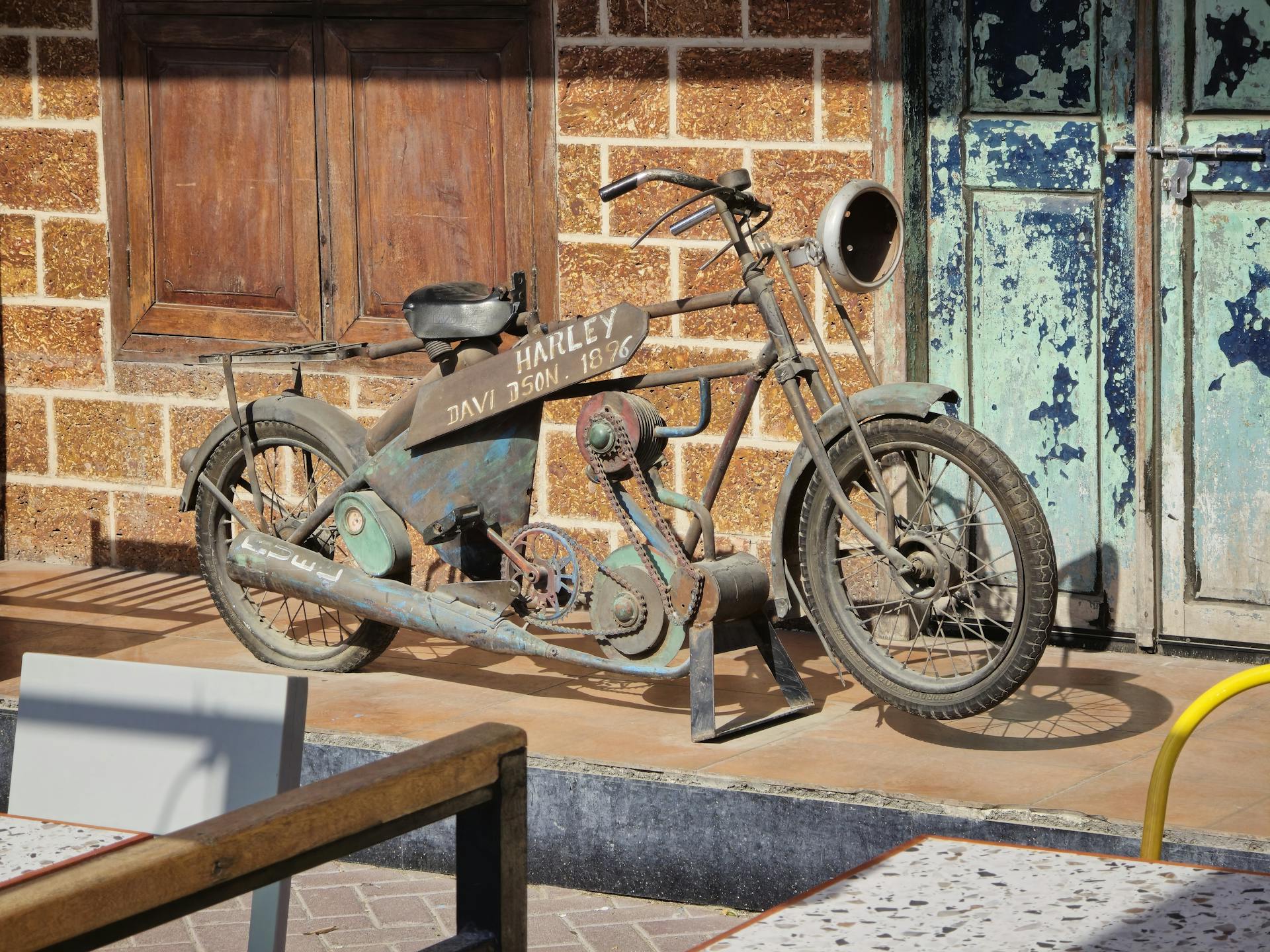 Rusty antique Harley Davidson motorcycle displayed outdoors in Dubai.