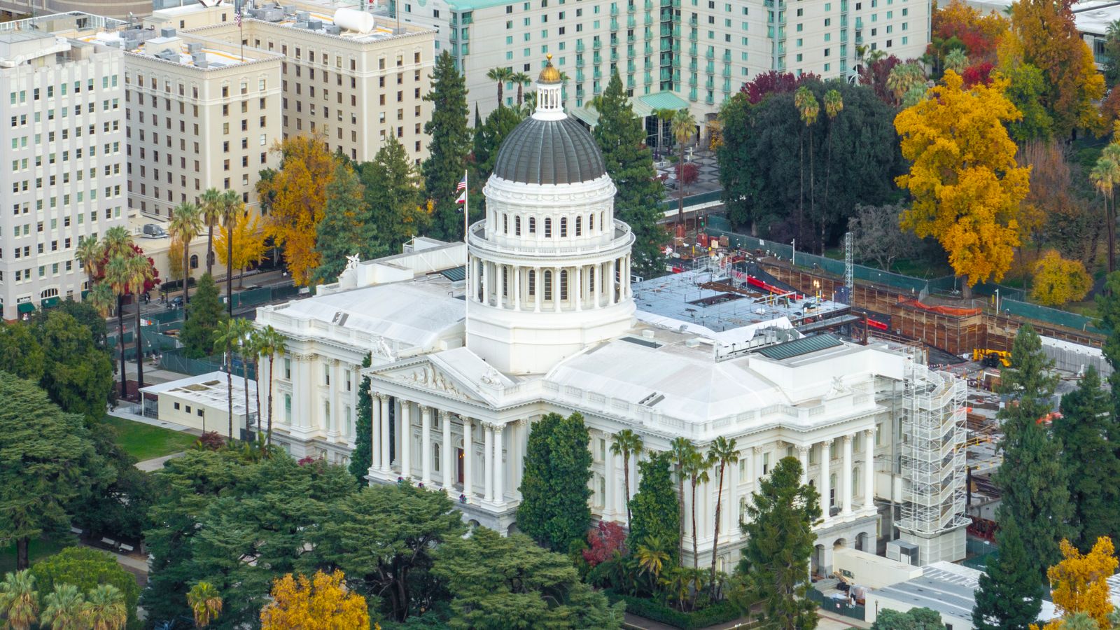 Aerial shot of the California State Capitol surrounded by colorful autumn foliage in downtown Sacramento.