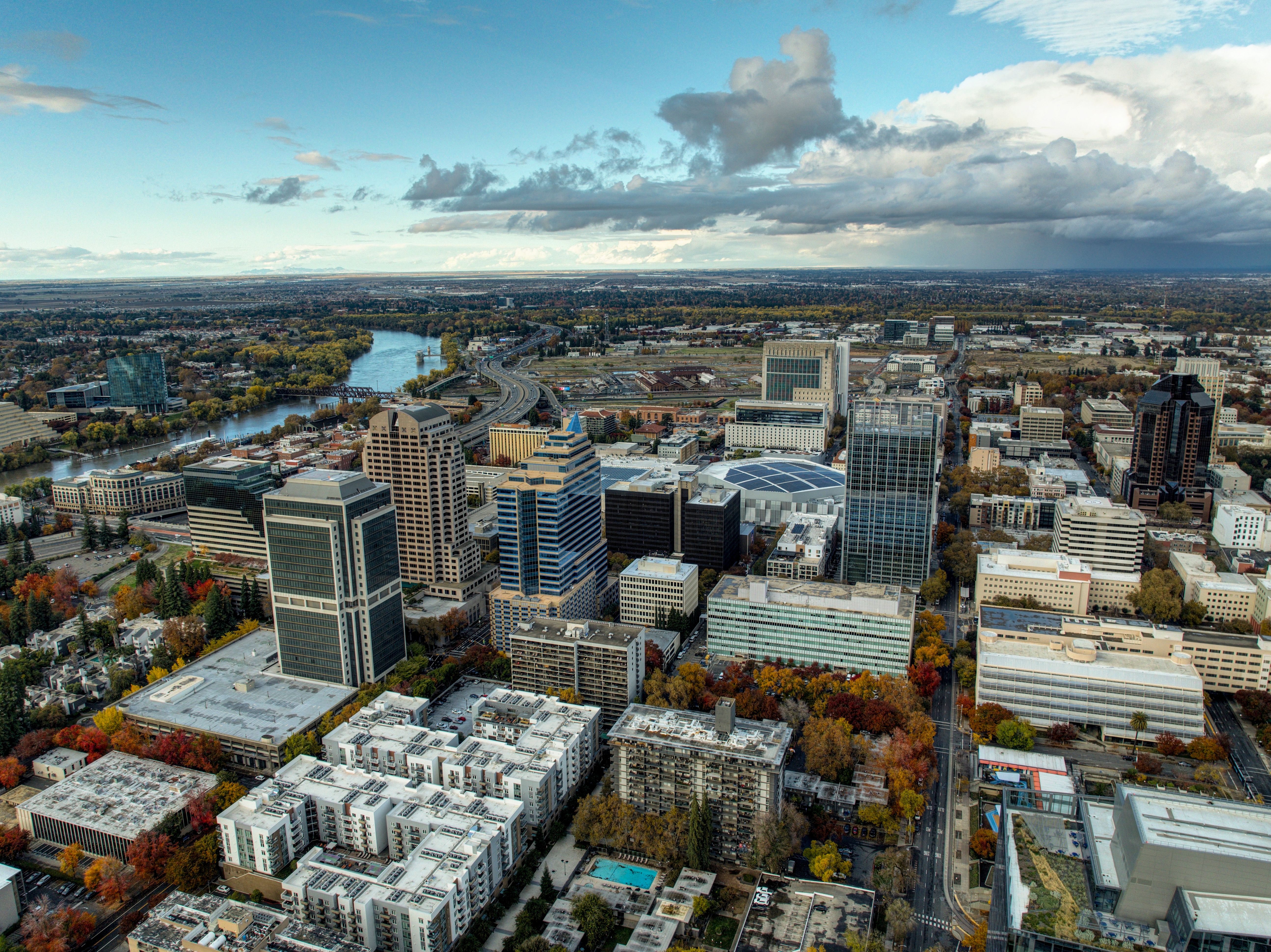 Stunning aerial view of Sacramento cityscape with autumn colors and dramatic sky.
