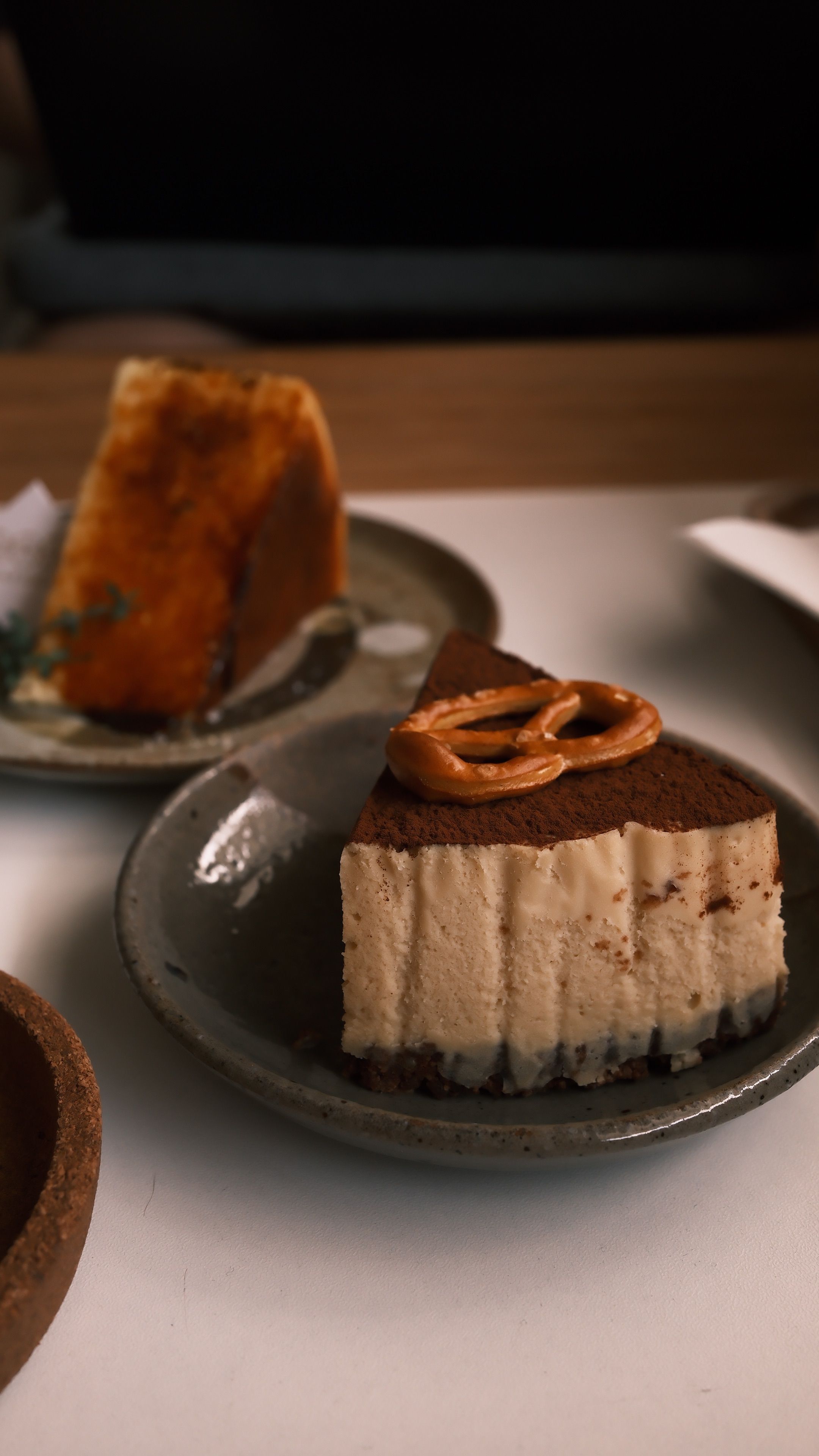 Close-up of a cheesecake slice with caramel topping served on a rustic plate, perfect for desserts.
