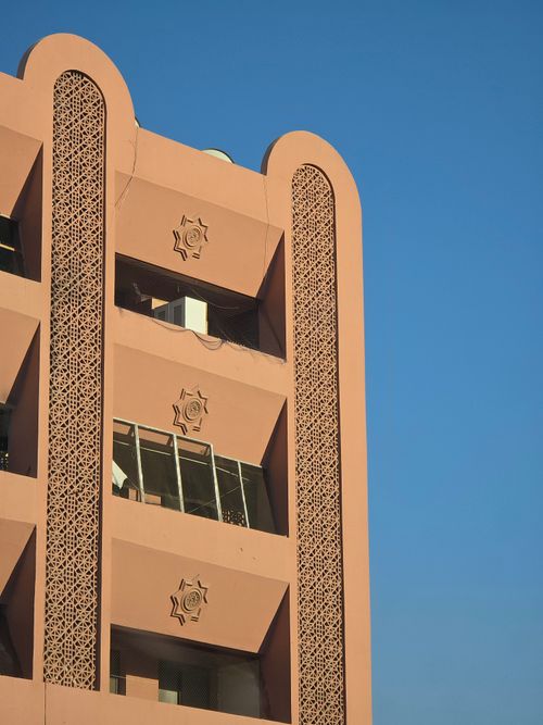 Free Exterior of a modern building showcasing Arabic geometric patterns against a clear sky. Stock Photo