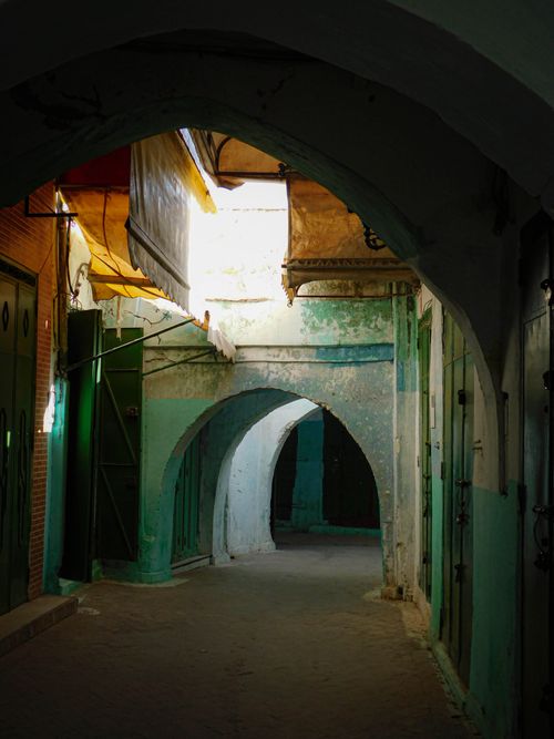 Free Explore a sunlit alleyway with traditional arches in a historic medina setting, rich in texture and color. Stock Photo