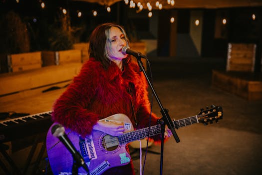Female singer in red jacket performing live music outdoors at night in Berlin.