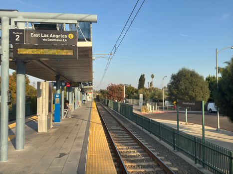 East Los Angeles train station platform with empty tracks during sunset.