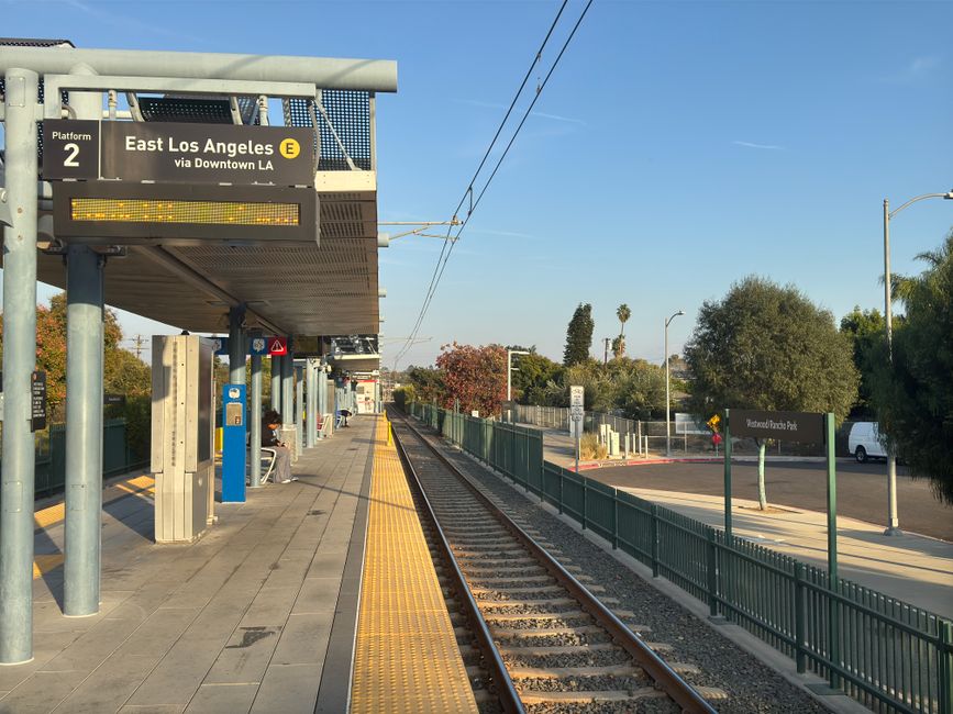 People boarding a public transport train connecting to a major US airport