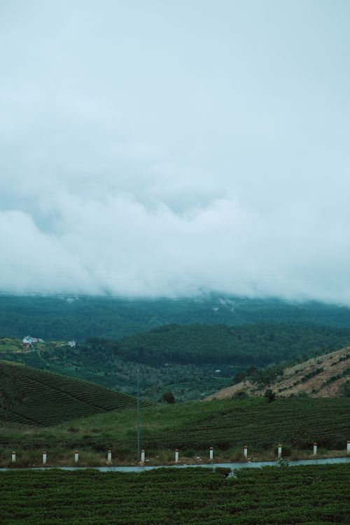 Free Breathtaking view of a vast mountain landscape covered in misty clouds and lush greenery. Stock Photo