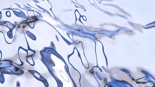 Free Blue and white abstract liquid metal texture with fluid reflections and smooth waves. Stock Photo