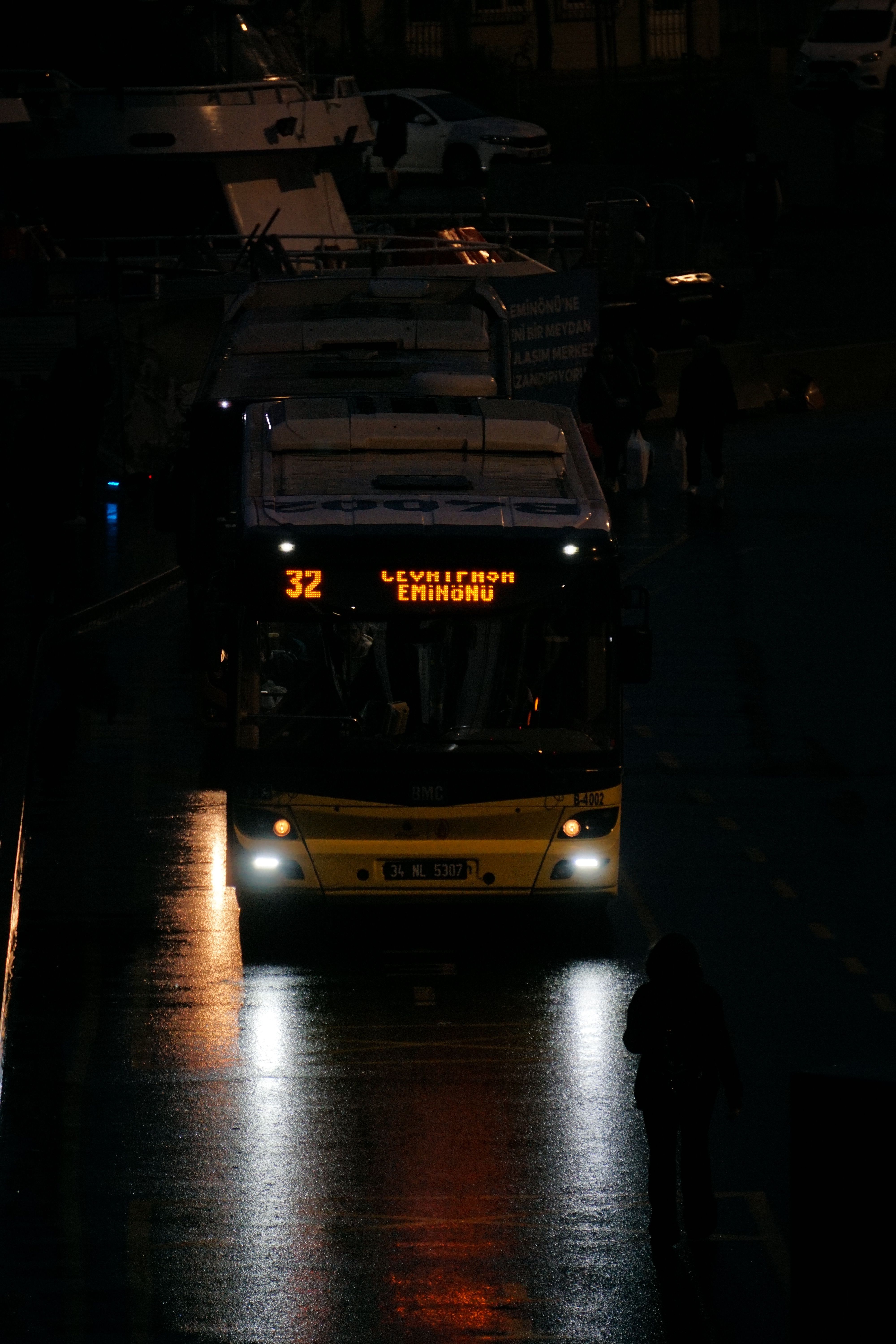 A city bus on a wet street at night with reflections. Late evening mood.