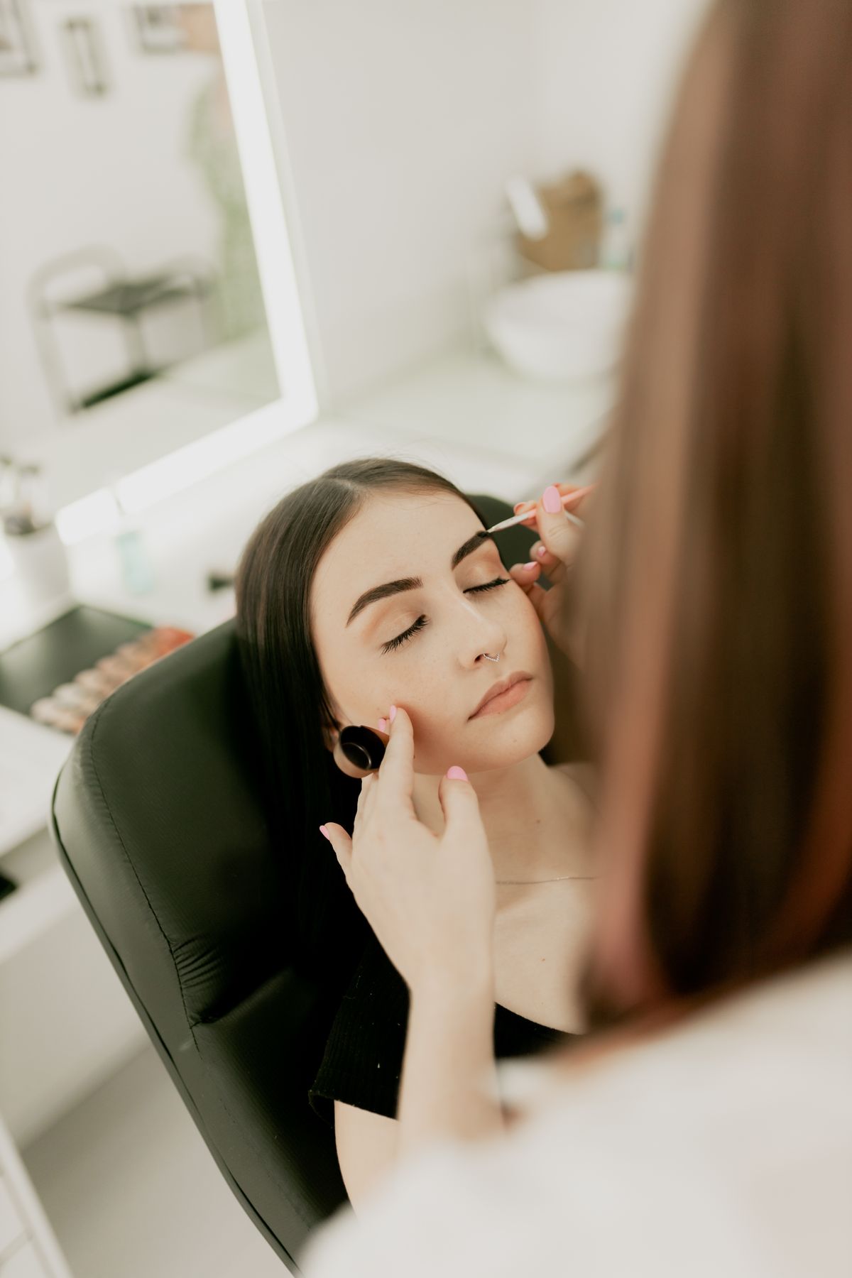 Professional makeup artist preparing a client for event lighting and photography