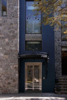 Modern building with stone facade and sleek entrance, reflecting architectural elegance.